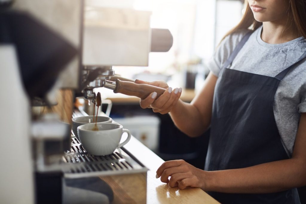 Barista preparando café en una cafetería del distrito de San Isidro, reflejo de la vibrante vida gastronómica que ofrece vivir en este exclusivo distrito de Lima