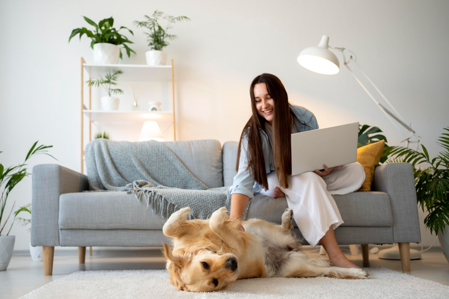 Mujer trabajando desde casa con su perro golden retriever en un departamento pet friendly de Miraflores, con diseño moderno y áreas verdes interiores