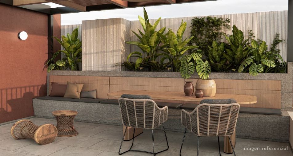 Terraza con áreas verdes y vegetación tropical en departamento sostenible en Lima, con mobiliario de materiales naturales y diseño eco amigable