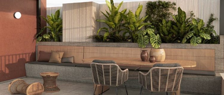 Terraza con áreas verdes y vegetación tropical en departamento sostenible en Lima, con mobiliario de materiales naturales y diseño eco amigable
